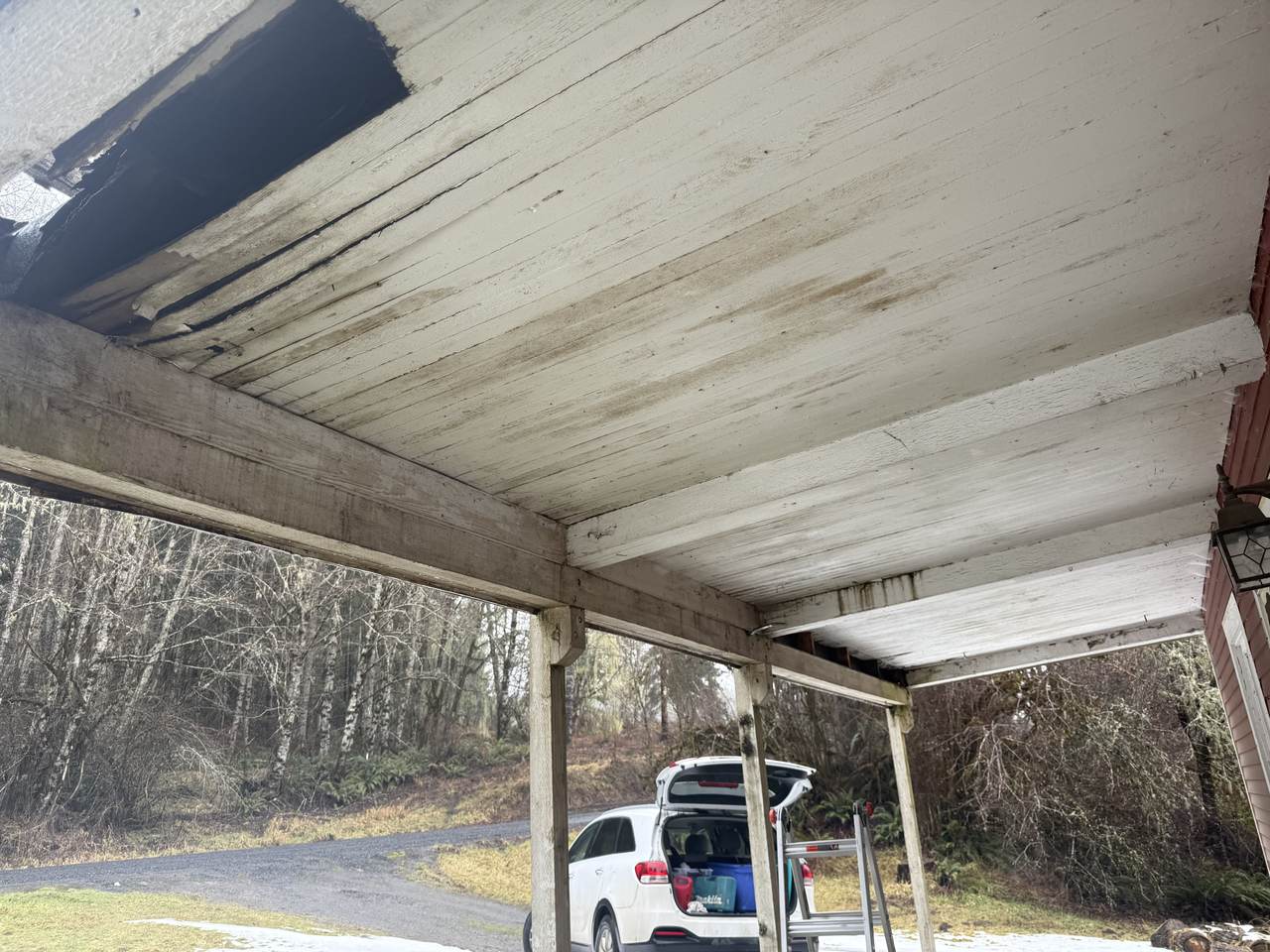 Porch ceiling with rotted boards and a hole open to the roof structure