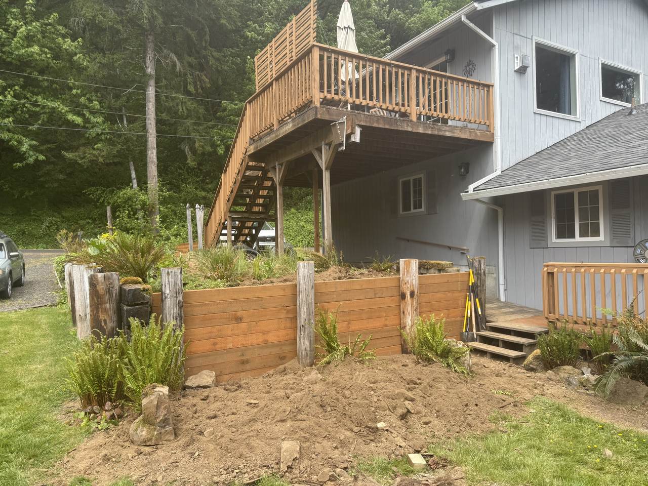 The same retaining wall rebuilt in new cedar between the original posts