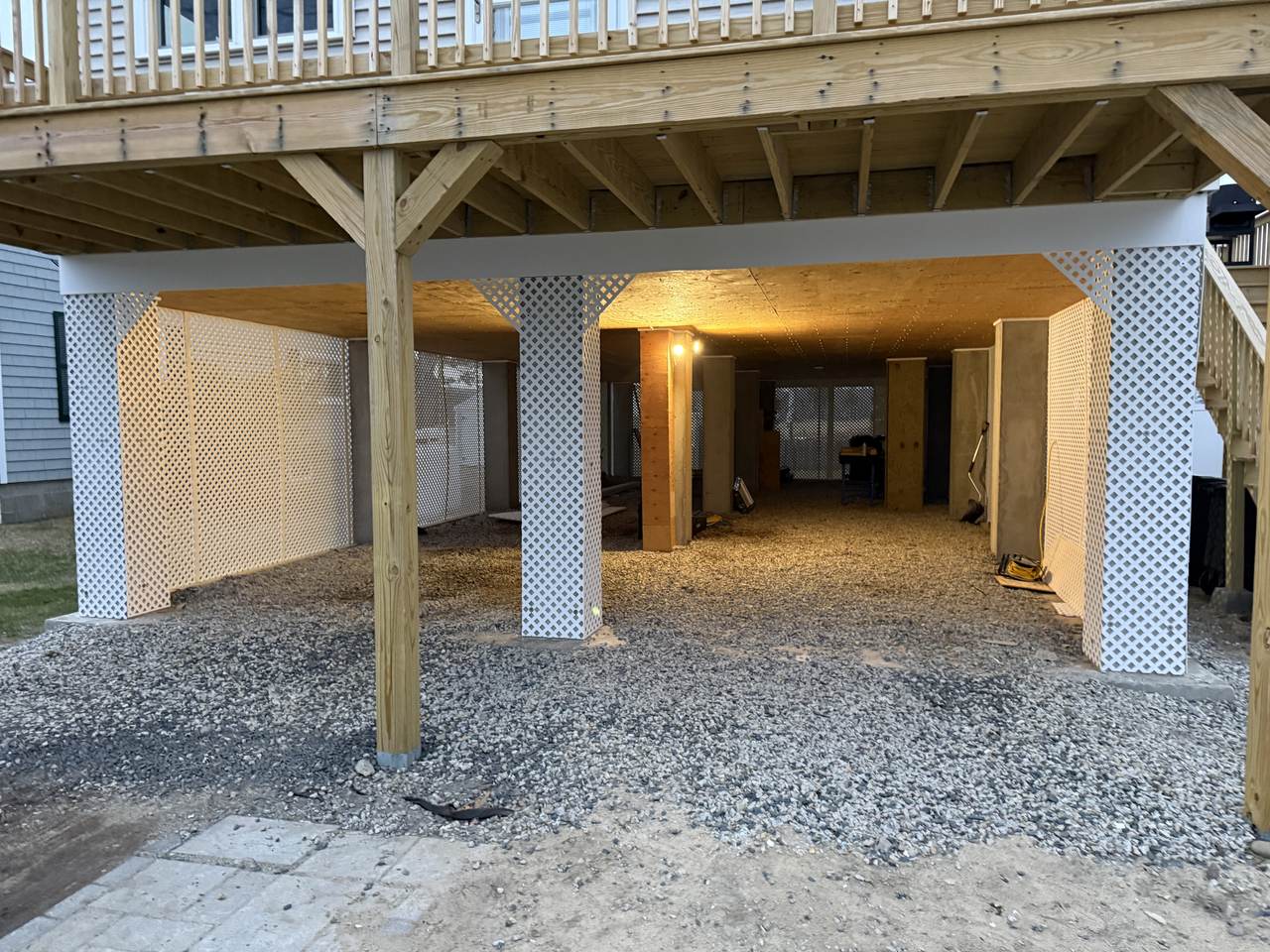 Finished lattice enclosure and gravel under a raised coastal deck